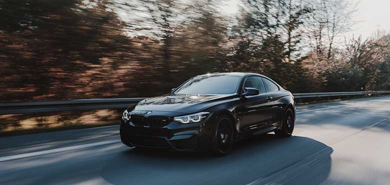 Bočni prikaz crnog automobila BMW na magistalnom putu