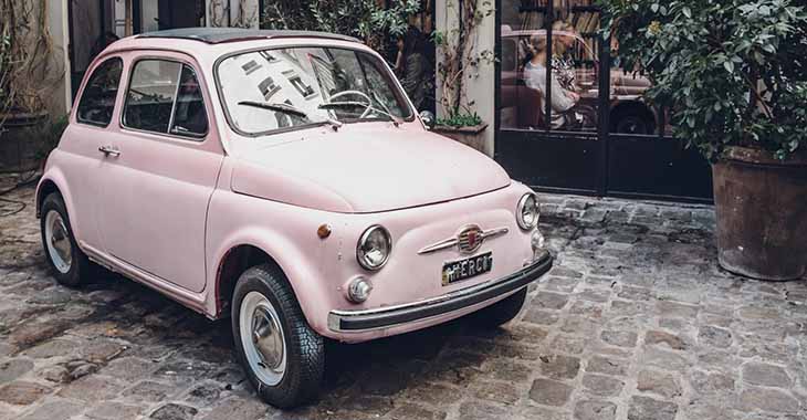 Roze Fiat 500 ispred kafića